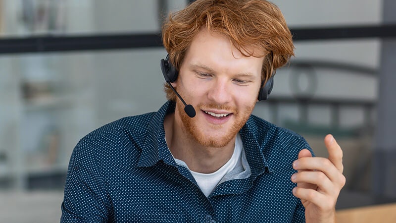 Person sidder og snakker i telefon via headset